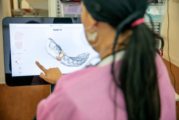 Dental Technician Analyzing 3D Tooth Model on Digital Scanner